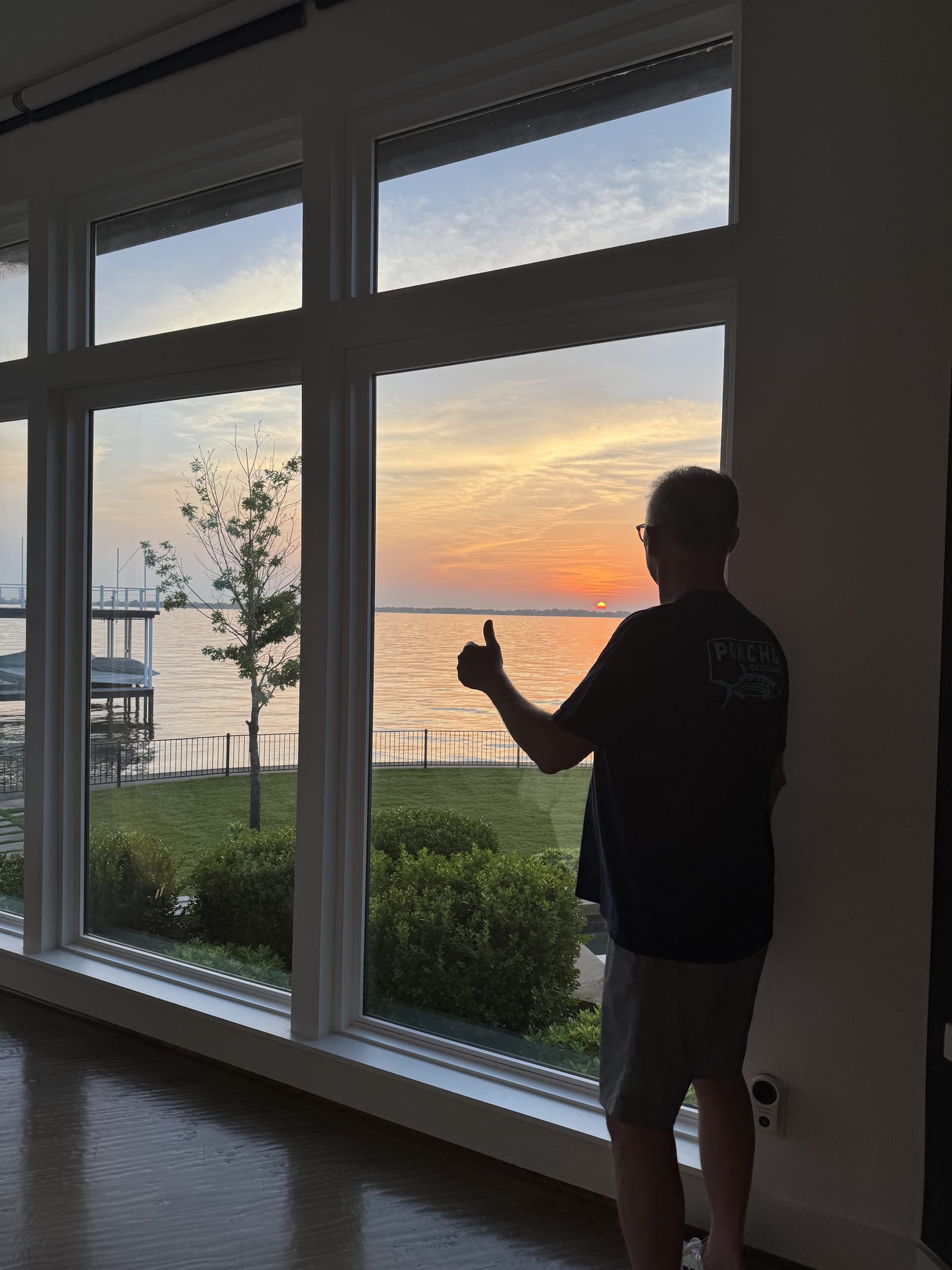 Homeowner enjoying a lakefront sunset through new EcoView windows
