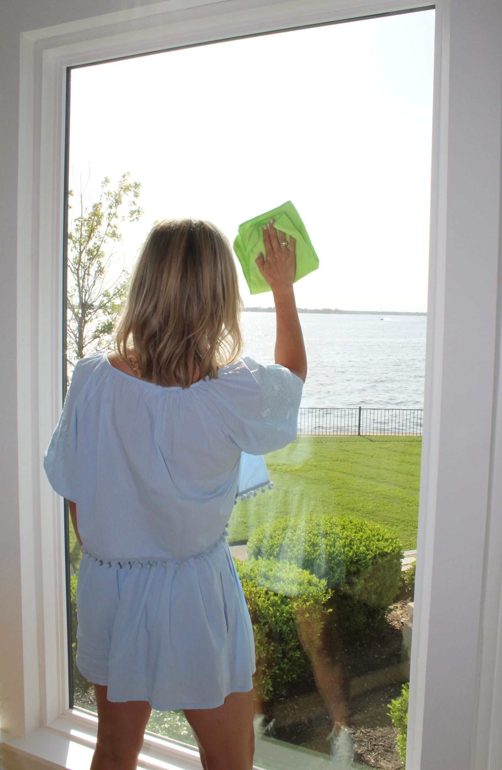 Homeowner cleaning a new lakefront window