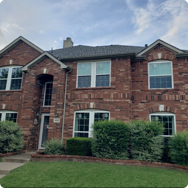 Red brick two-story home with new white replacement windows